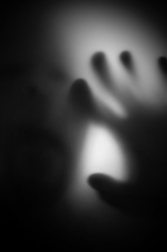 A ghostly hand on a window pane.